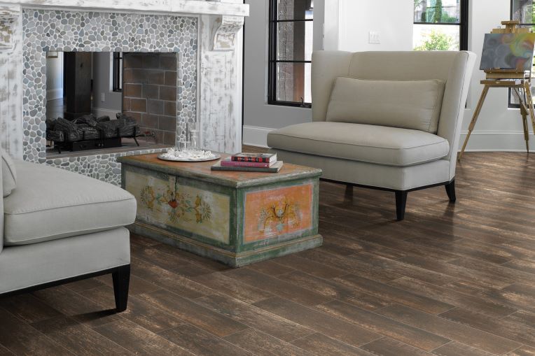 rich dark stained wood look tile floors in a classic living room with a stone fireplace